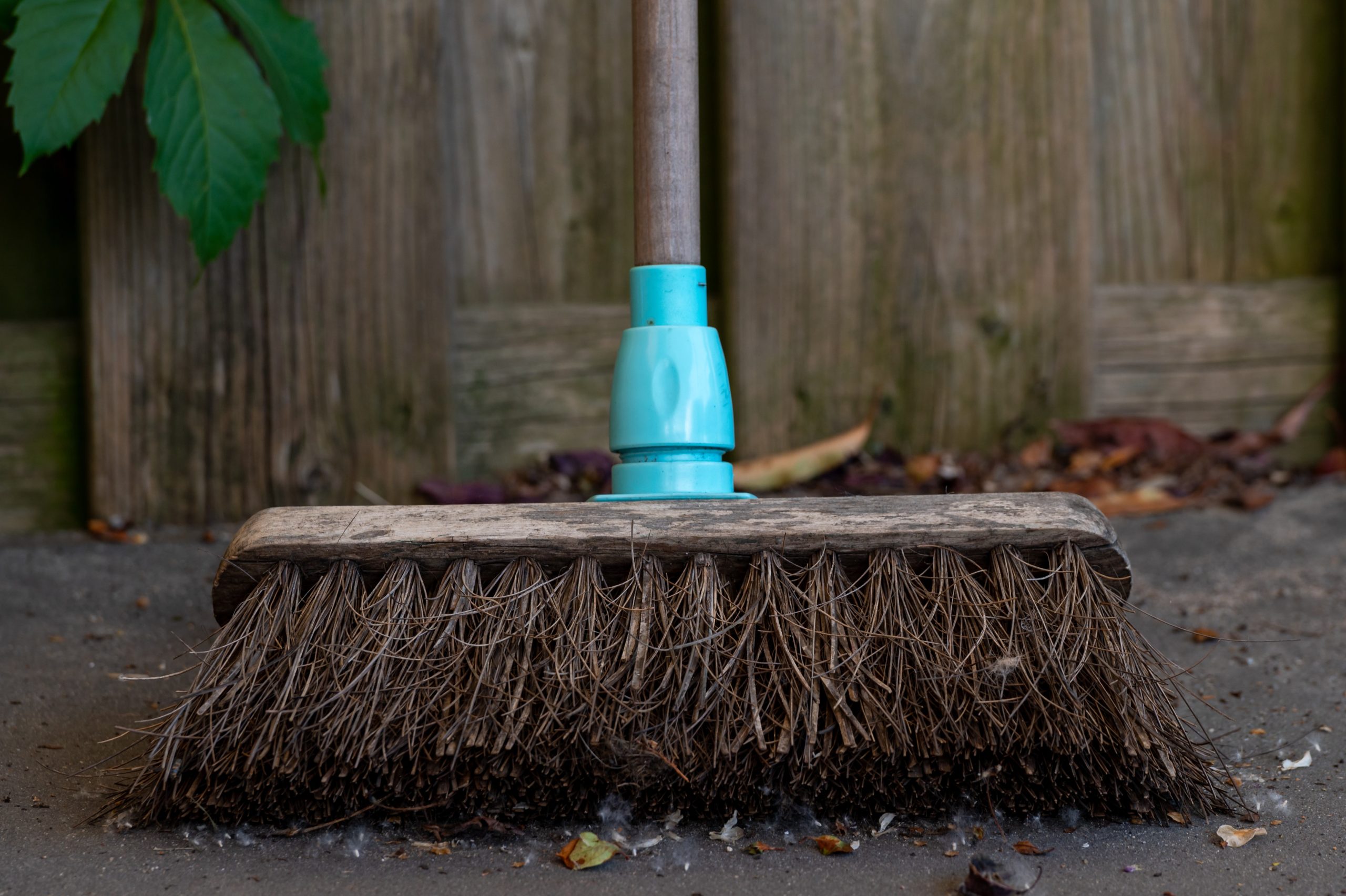 broom sweeping a dirty floor