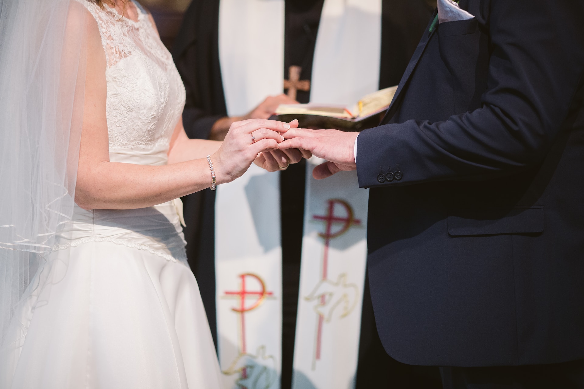 A bride and groom exchanging rings at their wedding Mass